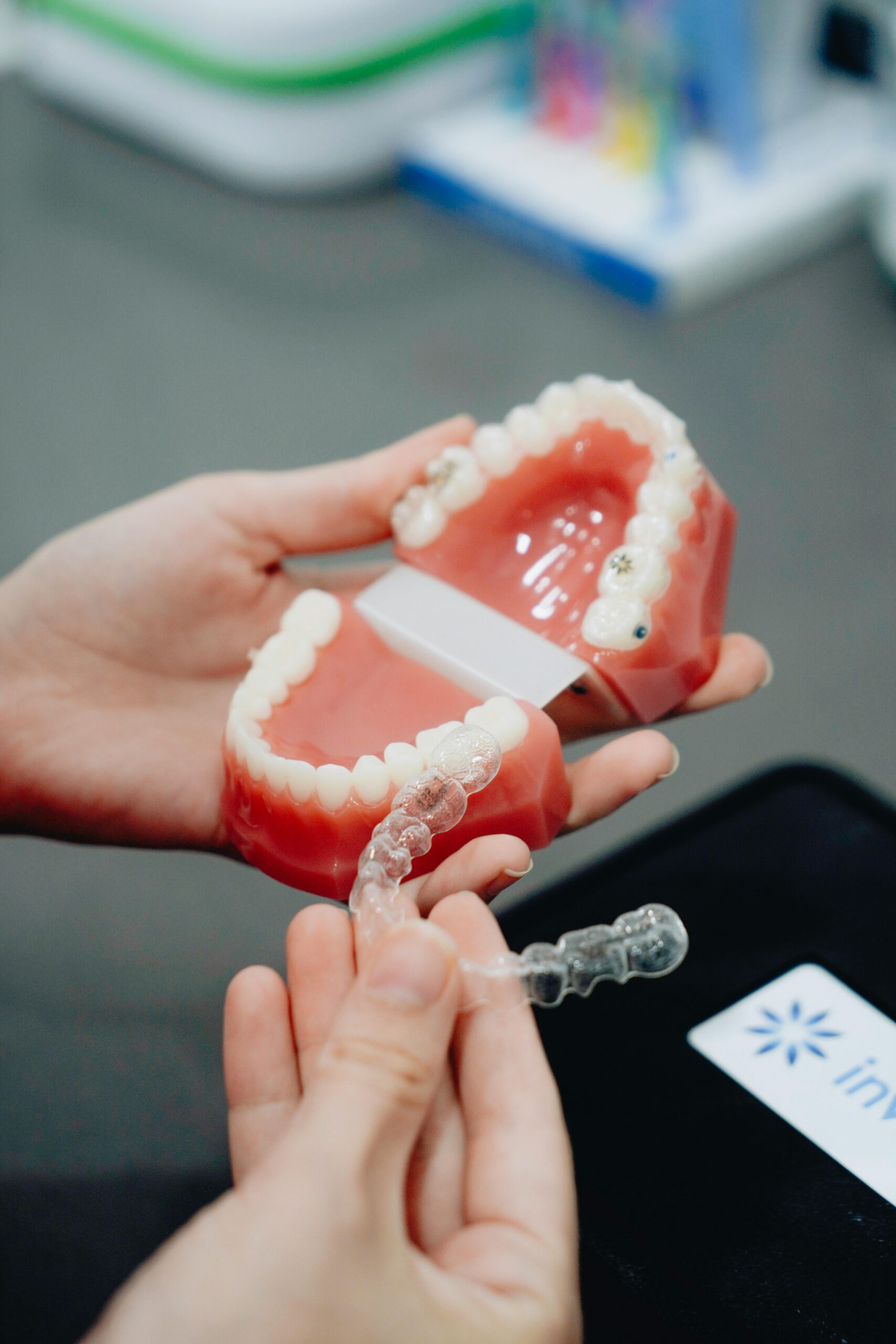 A close-up of hands holding a dental mold and clear aligner, perfect for orthodontic care visuals.