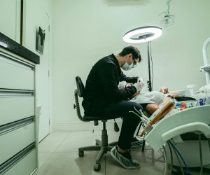 pexels-photo-11999476-11999476 A dentist wearing a mask treats a patient in a modern dental clinic in Brazil.